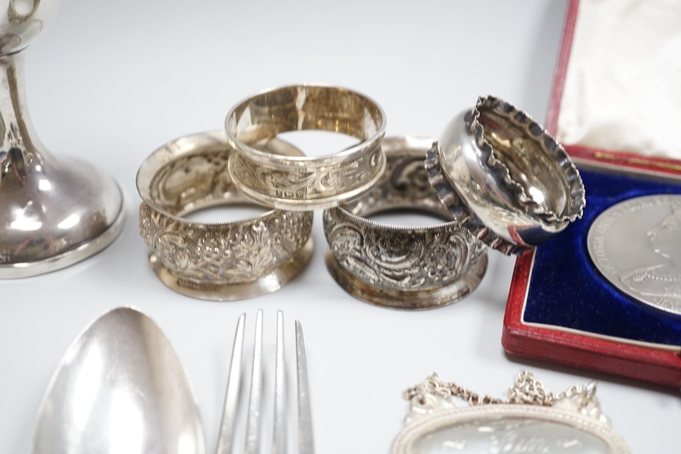 Sundry small silver including a George V goblet, cigarette case, vesta cases, flatware, wine labels and napkin rings including plated.